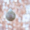 Christmas ball on abstract shimmering bokeh background