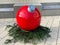 Christmas ball - x-mas ball - normally small little thing - in bright red with fir green on townhouse square in Ratingen, Germany