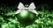 Christmas ball, silver satin ribbon bow on blurred green bright