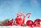 Christmas balls and candy canes in snowy winter setting.