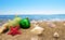 Christmas balls on sand with sea in background