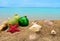 Christmas balls and shells on sand with summer sea