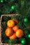 Christmas balls, tangerines and fir tree in a rustic wicker bask
