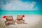 Christmas on beach -chair lounges with Santa hats at sea