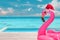 Christmas beach summer vacation flamingo pool float with santa hat travel background for winter holidays