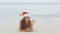 Christmas beach woman in santa hat waving hand