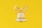 Christmas bell glass ice frosty texture decorated gold hanging ribbon. Graceful toy concept design yellow background. Elegant