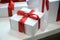 Christmas or birthday time. Gift boxes with red ribbons on wooden desk background