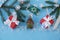 Christmas blue background with Christmas tree branch and red gift boxes with white ribbons, bell, sleigh and snowflakes. Flat lay.