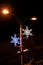 Christmas blue and white lights shape of frozen snowflakes. Street detail of Christmas decorations, string rice lights bulbs.