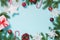 Christmas border with white and red decor, balls, gift, candy cane, snowflakes on blue. Flat lay. Top view. Copy space.