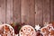 Christmas bottom border of assorted sweets and cookies. Top view over a wood background.