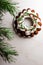 Christmas Bundt cake with white glaze and spruce branches over light background. Top view.