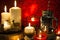 Christmas candles and holiday decorations on red blurred abstract background.