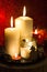 Christmas candles and holiday decorations on red blurred abstract background.