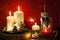 Christmas candles and holiday decorations on red blurred abstract background.