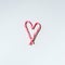 Christmas candy cane heart on grey background with copy space. Top view. Love, Valentines day concept. New year and Christmas card