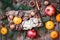 Christmas card. Christmas gifts, Cookies Chocolate, pomegranate, Tangerines, Nuts, cocoa beans, Fir branches on wooden table