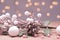 Christmas card in pink tinting. Christmas twig with cone, balls and lights