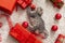 Christmas cat play with red gift boxes and balls. Flat lay. Beautiful little tabby kitten kitty cat near Christmas decorations at