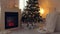 Christmas celebration in cozy interior with decorated new year tree, fireplace and merino plaid