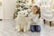 Christmas Child girl hug dog Samoyed. Christmas, winter and people concept