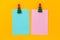 christmas clothespins and pink and blue blank paper sheets with free space for text on a vibrant yellow background