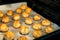 Christmas coconut puffs macaroon cookies on parchment paper on tray in oven. Festive cozy home atmosphere. Holiday pastry baking