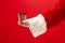 Christmas coffee. The Santa hand holding cup of cofee isolated on a red background with space for text