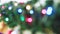 Christmas colored lights burn brightly out of focus.