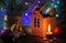 Christmas composition with a burning candle, a house and Christmas decorations on a table