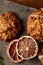 Christmas composition with chocolate biscuits, cinnamon and dried oranges on wooden background, close-up.