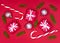 Christmas composition. Christmas decorations, fir tree branches, giftboxes and candycanes on red background. Flat lay.