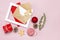 Christmas composition. Envelope with blank white paper, fir branches, cones, red ball, twine, gift, wooden toys on pink background