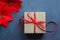 Christmas composition. Gift box with red satin ribbon on a black background. Christmas decor.