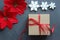 Christmas composition. Gift box with red satin ribbon, wood and snowflakes on black background. Toys Christmas decor.
