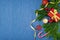 Christmas composition with gifts, gold tinsel, pine cones, candle, fir branches and snowflakes on a blue background