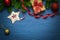 Christmas composition with gifts, red tinsel, nuts, red balls, fir branches and star on a blue background