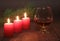 Christmas Composition with glass cognac, Gift box and candle on wooden table