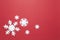 Christmas composition, group of big and small white felt snowflakes on burgundy red background, copy space. Festive, New Year