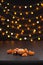 Christmas composition. Mandarins, tangerine slices, tangerine peel on black background of blurred defocused multicolor lights.