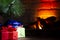 Christmas composition, many colorful gifts under the tree near the burning fireplace, close-up