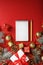 Christmas composition with notepad and a pencil for writing wishes with Christmas tree decorations on a red background