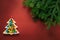 Christmas composition. A plate in the shape of a Christmas tree filled with colorful candies. Branches of spruce on a