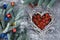 Christmas composition. red and blue gift boxes in wicker basket in the shape of a heart, fir branches on a gray background,
