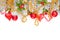 Christmas composition with red holly berries, glass baubles, golden garland and green Xmas tree branch isolated on white