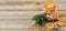 Christmas composition with spruce tree branches, cinnamon sticks and garland made of dried slices of oranges on wooden background