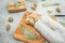 Christmas composition with stollen cake on a wooden board, cutlery and gift on gray