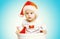 Christmas concept - beautiful baby in santa red hat gets out of the container