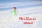Christmas concept. Glass snowman on the snow, with the phrase Meilleurs voeux.